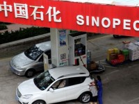 A customer gets the tank of her car filled at a Sinopec gas station in Qingdao, Shandong province September 11, 2014.   REUTERS/Stringer